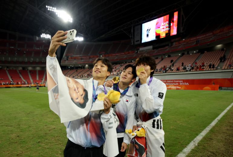 Asian Games - Aichi-Nagoya 2026 - Soccer Football - Men's Final - South Korea v Japan - Toyota Stadium, Toyota, Japan - October 3, 2026 Gold medallist South Korea's Jisung Eom takes a selfie with teammates during the victory ceremony REUTERS/Andrew Boyers