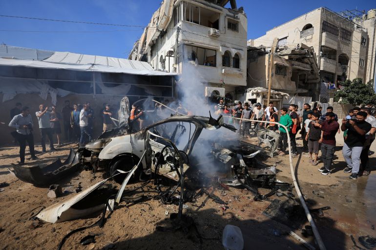 فلسطينيون يتجمعون حول بقايا مركبة بعد أن ضربتها غارة إسرائيلية، بحسب مسؤولي الصحة، في مدينة غزة، 22 أكتوبر، 2026. رويترز / داود أبو الكاس