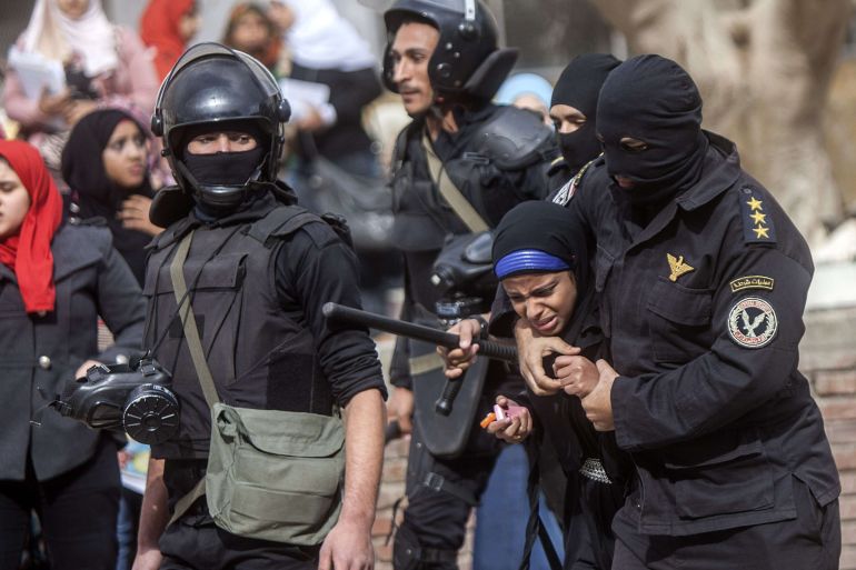 An Egyptian riot policeman detains a female student of al-Azhar University during a protest by students who support the Muslim Brotherhood inside their campus in Cairo on December 30, 2013. Egypt urged Arab League members to enforce a counter terrorism treaty that would block funding and support for the Muslim Brotherhood after Cairo designated it as "terrorist" group. AFP