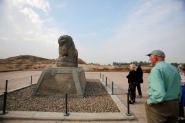Foreign tourists look at the statue of the Lion of Babylon inside the ancient city of Babylon near Hilla, south of Baghdad