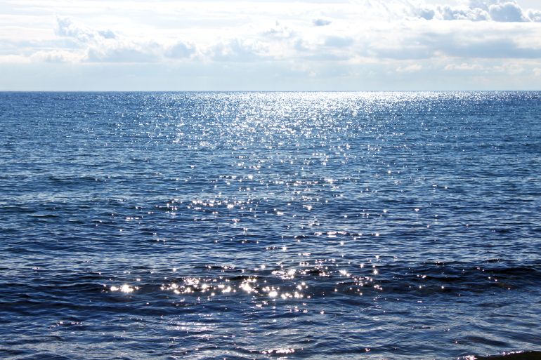 Sun reflecting on sparkling blue sea