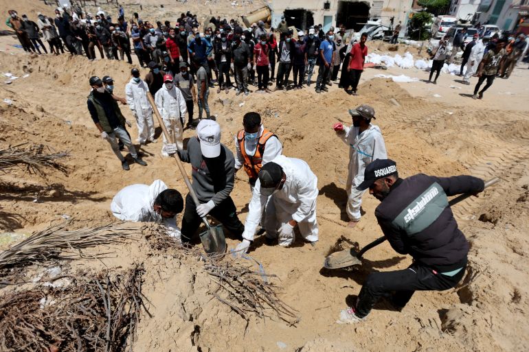 People work to move into a cemetery bodies of Palestinians killed during Israel's military offensive and buried at Nasser hospital, amid the ongoing conflict between Israel and the Palestinian Islamist group Hamas, in Khan Younis in the southern Gaza Strip, April 21, 2024. REUTERS/Ramadan Abed TPX IMAGES OF THE DAY